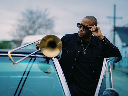 Man with trombone stepping out of a car